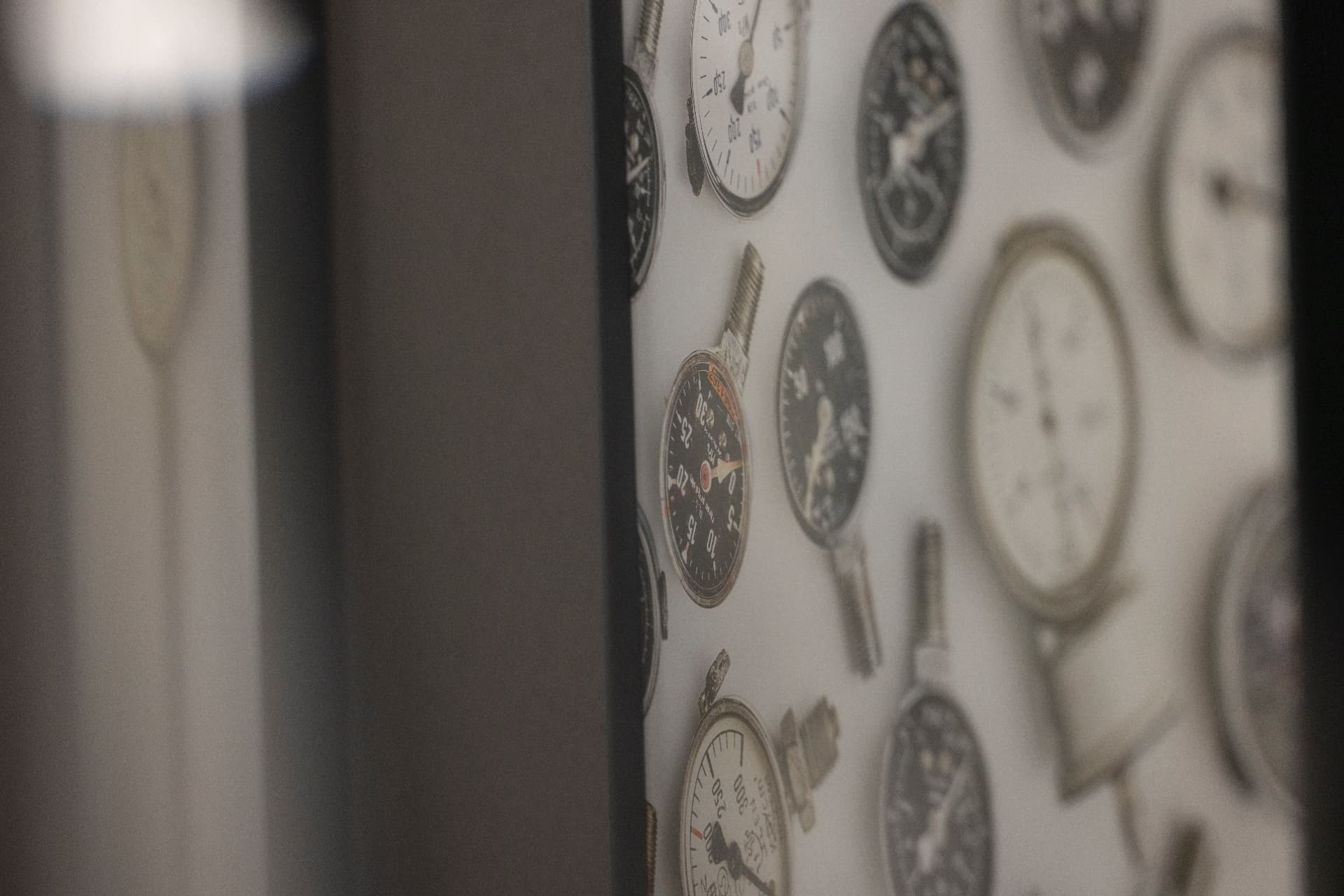 Framed photograph of a wall with vintage pressure gauges and stopwatches