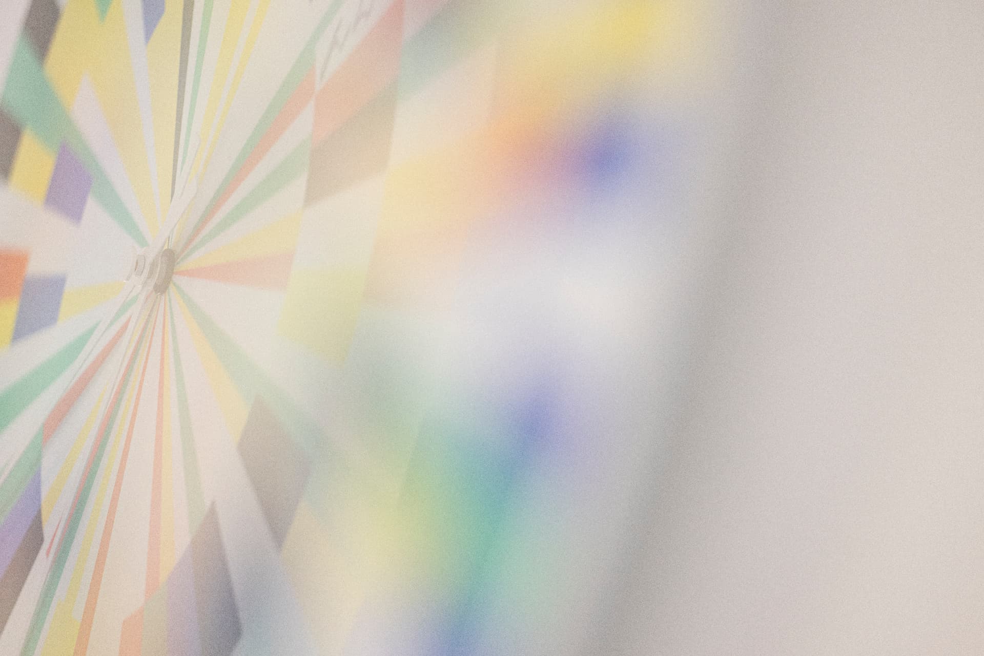 Pastel-coloured radial wall clock graphic with rainbow reflection