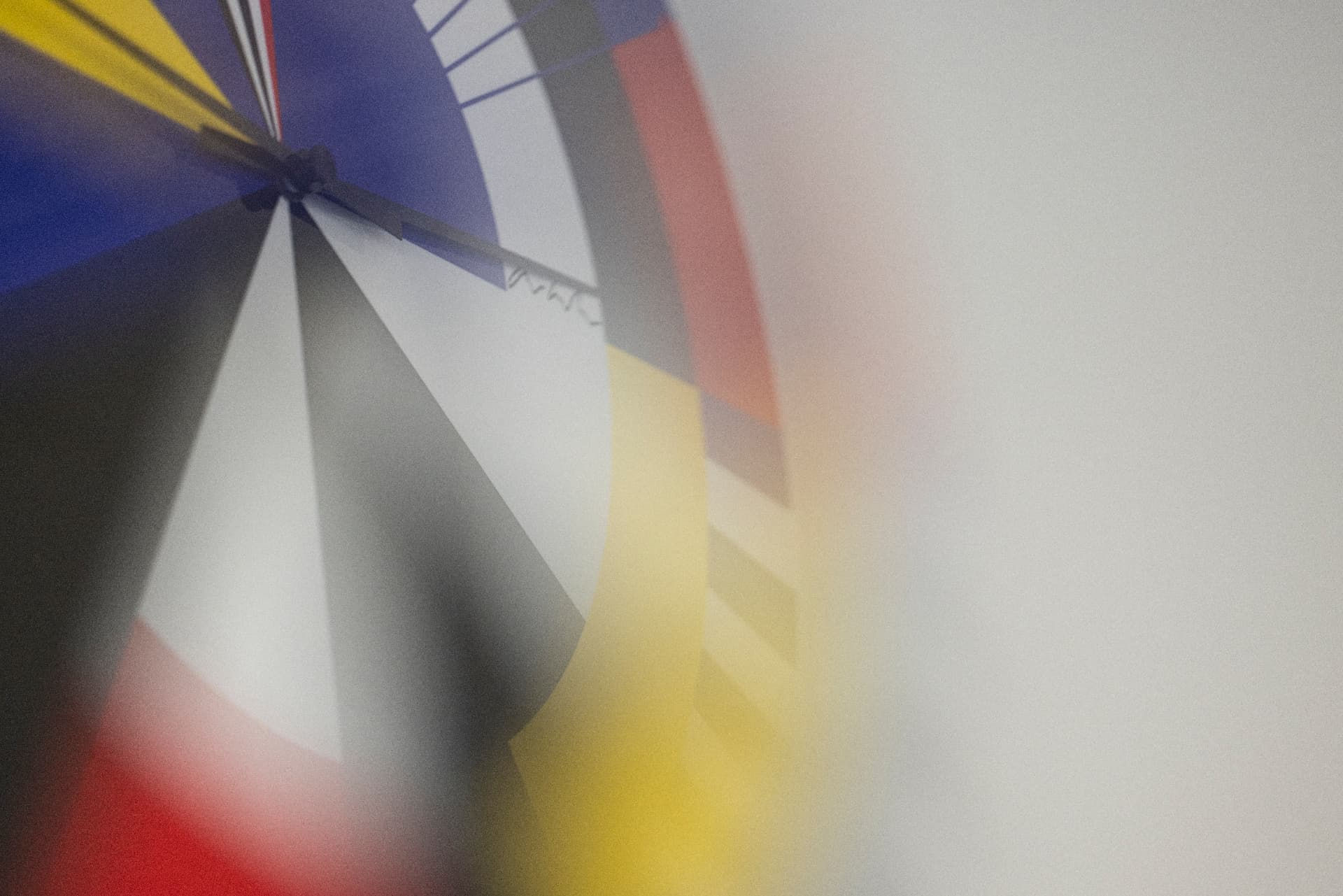 Detail of a colourful Bauhaus wall clock with blue, red and yellow segments